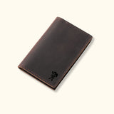 Dark brown genuine leather cardholder with a sleek, minimalist design and rugged stitching, part of The Rancher's Legacy collection.