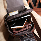 Interior view of the Croc Ridge Leather Sling Bag loaded with items including a phone, wallet, and other essentials, showcasing the spacious main pocket and smaller pockets.
