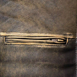 Close-up detail of a distressed leather jacket, showcasing the texture and zipper craftsmanship.