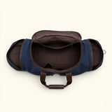 Open interior view of The Weekender navy waxed canvas and leather duffel with a spacious main compartment, zippered pocket, and two side compartments.