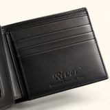 Close-up of The Ashford crocodile bifold wallet interior, highlighting smooth full-grain calf leather, precision stitching, card slots, and the embossed RIVER logo.