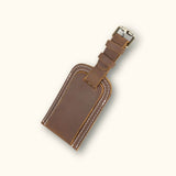 Close-up of a brown leather tag with visible stitching, showing its texture and quality craftsmanship.