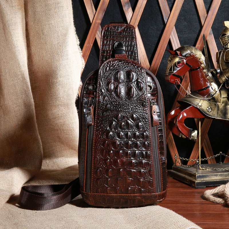 Display of the Croc Ridge Leather Sling Bag - Claw Style, showcasing its rich brown leather with a distinctive crocodile pattern, set against a rustic background with a knight figurine.