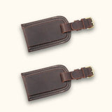 A set of dark brown leather tags, characterized by their rich hue and durable craftsmanship, perfect for adding a touch of sophistication to your belongings while ensuring easy identification during travel.