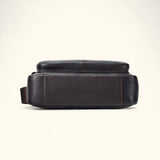 Bottom view of The Dustwalker full-grain cow leather crossbody iPad bag in coffee brown showing reinforced stitching and durable leather base.