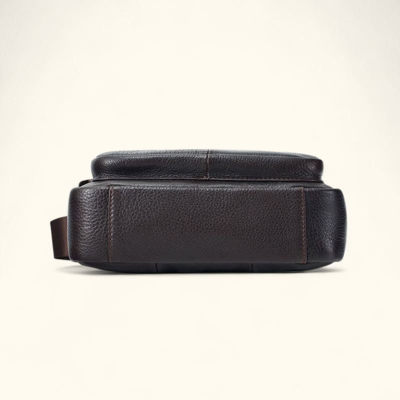 Bottom view of The Dustwalker full-grain cow leather crossbody iPad bag in coffee brown showing reinforced stitching and durable leather base.
