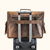 Leather Satchel Bag: Briefcase atop suitcase, secured with trolley strap.
