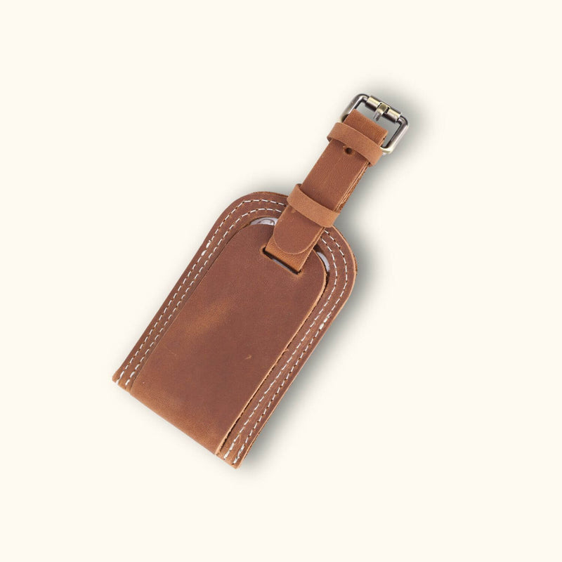 Close-up of a light brown leather tag, showcasing its smooth surface and subtle grain pattern, with visible stitching adding a touch of craftsmanship.