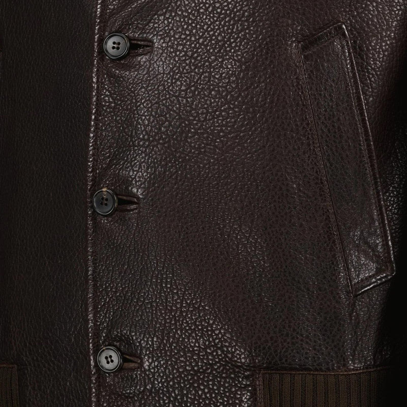 Close-up view of the buttons and texture of a brown leather jacket.