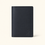 The Rancher's Legacy black leather cardholder wallet standing upright with embossed cowboy logo and hand-stitched edges.