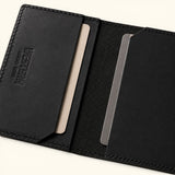 Interior detail of The Rancher's Legacy black minimalist leather cardholder showing card slots, cut-corner pockets, embossed branding, and textured center lining.