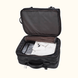 The Stetson Peak - Expandable Men's Leather Backpack in dark brown, open to reveal a spacious compartment with neatly packed clothing, demonstrating its use as travel luggage.