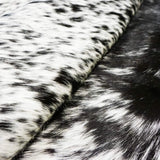 Folded Texas Range Black and White Cowhide Rug showcasing detailed texture.