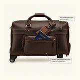 The Lawful Leather Duffle with Wheels featuring a front organizer pocket for everyday essentials and a quick access top zipper pocket, with a passport partially visible to demonstrate convenient travel organization.