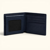 The Monarch Crocodile Bifold Wallet in Deep Midnight Blue featuring a premium leather interior with six card slots, dual slip pockets, a bill compartment, and an ID window, displayed open on a soft ivory background.