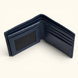 The Monarch Crocodile Bifold Wallet in Deep Midnight Blue shown in a top interior view, featuring a premium leather interior with six card slots, dual slip pockets, an ID window, and a full-length bill compartment on a soft ivory background.
