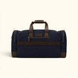 Back view of The Weekender navy waxed canvas and leather duffel with a zippered pocket, luggage sleeve, and reinforced leather handles.