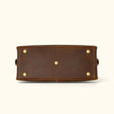 Bottom view of The Wolf heavy-duty leather duffel featuring five protective brass feet, reinforced stitching, and a durable structured base.