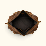 Open interior view of The Wolf spacious leather weekender bag showing its wide zip opening, black fabric lining, and interior storage pockets.