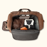 The Homesteader - Western Luxury Leather Duffel Bag, displaying an open top view that reveals the spacious interior with various compartments, packed with clothes and accessories for a neat and organized travel experience.