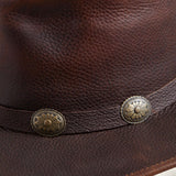 Close-up of the Walker leather hat showing full-grain leather texture and antique concho band