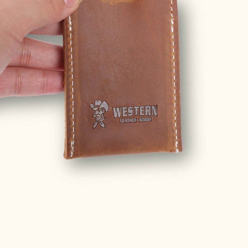 A Western-style leather tag, featuring rustic accents and intricate details reminiscent of traditional cowboy craftsmanship, adding a touch of rugged charm to your belongings.